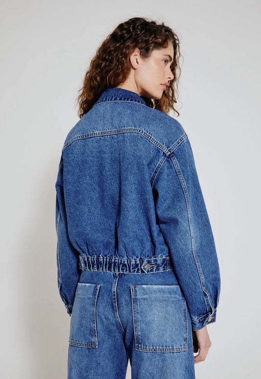 Modelo de costas usa jaqueta jeans oversized